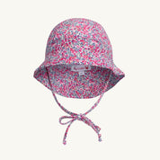 Floral patterned baby sun hat with a tie on a white background
